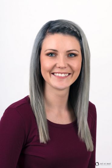 Smiling, friendly, approachable headshot of a young female professional in Calgary
